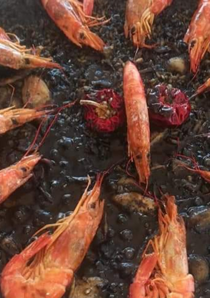 Una foto de Arroz negro con sepia y gambas