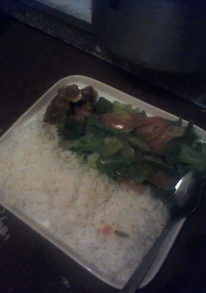 A picture of White rice green salad and beef.