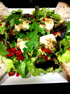 Una foto de Ensalada capriccio con queso de cabra, nueces y pan de quinoa