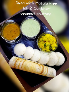 A picture of Dosa with masala aloo,idli & sambhar,coconut Chutney.