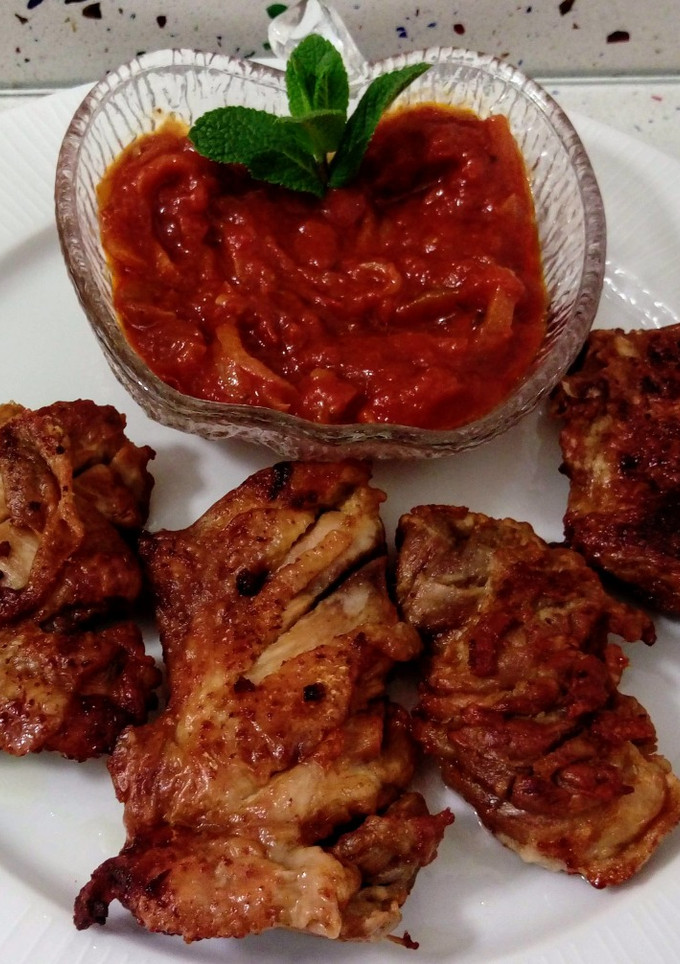 Una foto de Pollo al ajillo y tomate frito