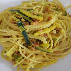 A picture of Spaghetti with speck, courgette and pumpkin flowers.