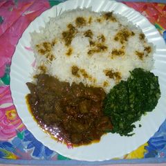 A picture of Coconut rice with steamed spinach and beef stew.
