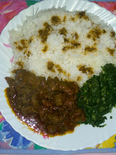 A picture of Coconut rice with steamed spinach and beef stew.