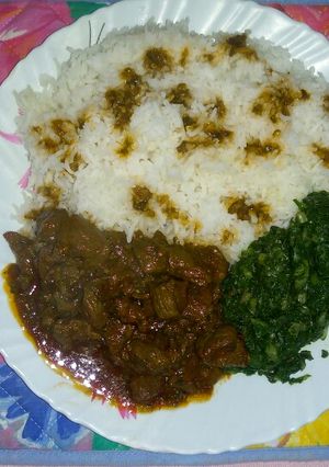 A picture of Coconut rice with steamed spinach and beef stew.