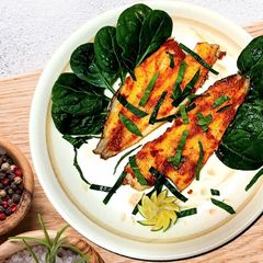 A picture of White fish in red pesto in the oven.