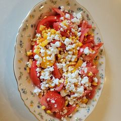 A picture of Tomato, peach and corn salad.