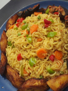 A picture of Indomine with fried plantain,snails and vegetables.