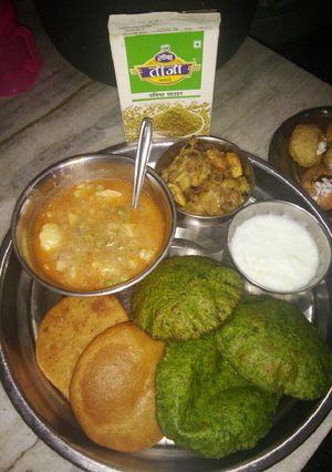 A picture of Aloo matar ki sabzi with poori.