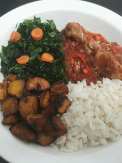 A picture of Rice,Fried plantain with vegetable and tomatoe stew.