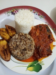 A picture of White Rice, Beans, Plantain and Cat Fish Stew.