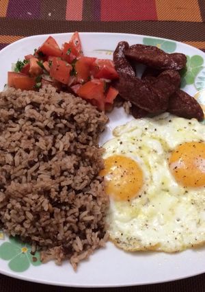 Una foto de Arroz con Frijoles, Chorizo y Huevos Fritos, Ensalada de Tomate