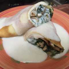 A picture of Panqueques rellenos con pollo y espinaca.