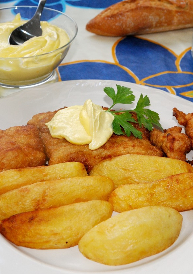 Una foto de Merluza rebozada con salsa Rouille y gajos de patatas