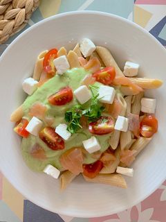 Una foto de Pasta fría con salsa de aguacate, tomate cherry, salmón y queso feta