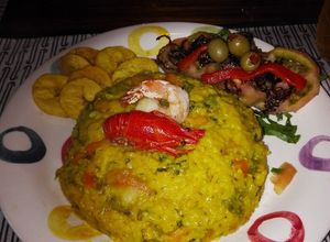 Una foto de Risotto frutti di mare con monedas de plátano verde y ensalada