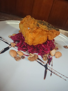 Una foto de Bacalao frito sobre ensalada a de Lombarda marinada y frutos