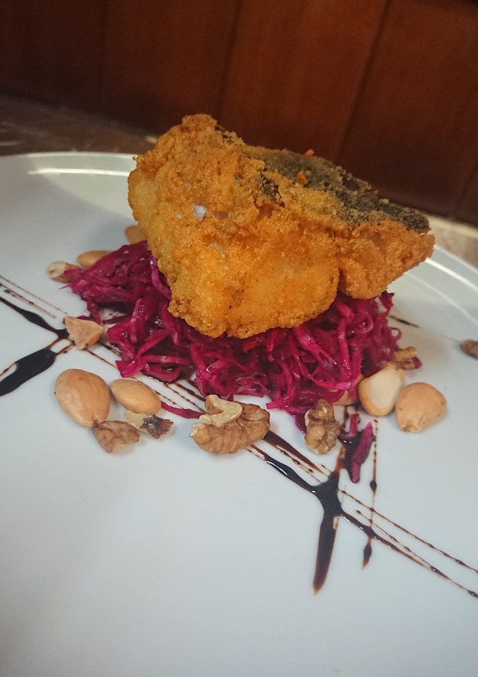Una foto de Bacalao frito sobre ensalada a de Lombarda marinada y frutos
