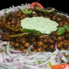 A picture of Fry Channay with salad and Mint Chutney.