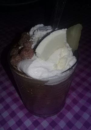 Una foto de Helado de chocolate, con crema chantilly de anana