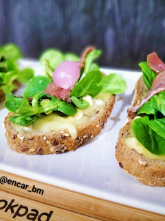 Una foto de Tosta de camembert, canónigos y anchoas