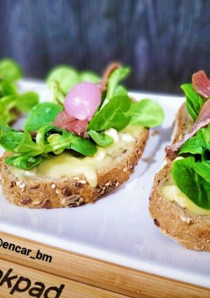 Una foto de Tosta de camembert, canónigos y anchoas