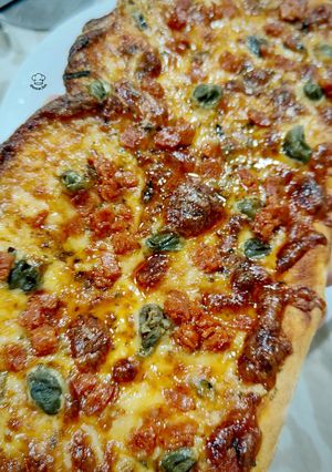 Una foto de Pizza de pepperoni y gorgonzola con alcaparras