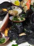 Gnocchi al nero di seppia con molluschi,prezzemolo e aglio