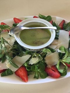 Una foto de Ensalada de rúcula, canónigos, fresas y parmesano