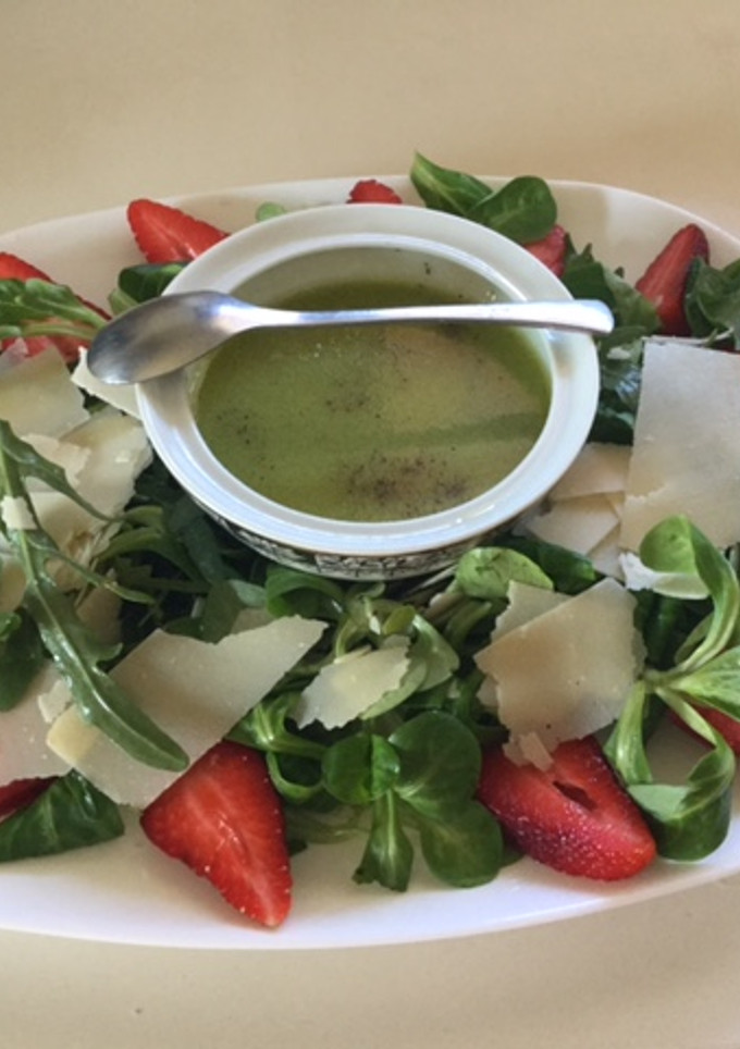 Una foto de Ensalada de rúcula, canónigos, fresas y parmesano