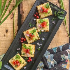A picture of Herb crackers with cheese and veggies.