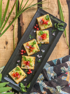 A picture of Herb crackers with cheese and veggies.