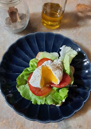 Une photo de Oeuf poché sur son lit de laitue et tomate
