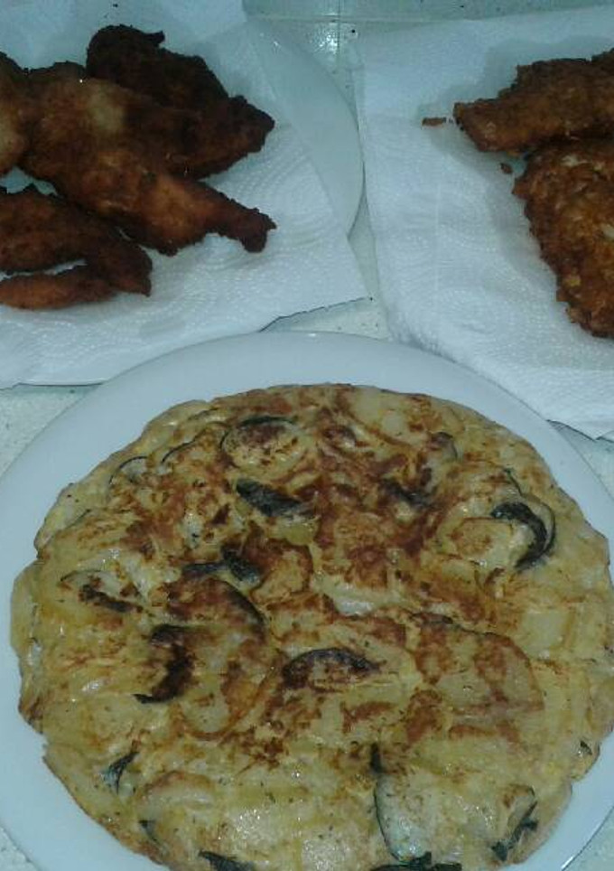 Una foto de Tortilla de patata con calabacín y de acompañamiento pechuga de pollo con cereales o pan rallado