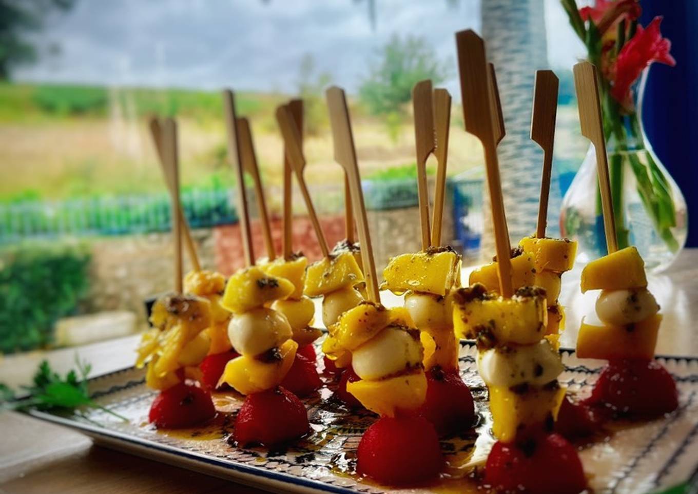 Bocaditos de sandía, mango y mozzarella con pesto