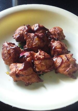A picture of Banana pakoda with honey and chocolate syrup.