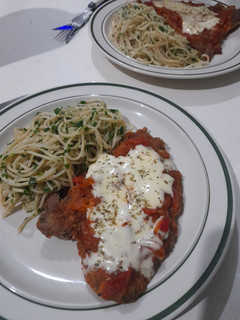 Una foto de Milanesa napolitana con fideos al pesto