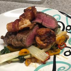 A picture of Filet Mignon w/ Bacon-wrapped Shrimp over Spiced Bok Choy.