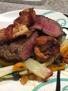 A picture of Filet Mignon w/ Bacon-wrapped Shrimp over Spiced Bok Choy.