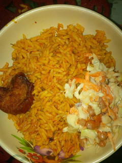 A picture of Jollof rice, coleslaw and chicken.