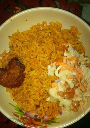 A picture of Jollof rice, coleslaw and chicken.