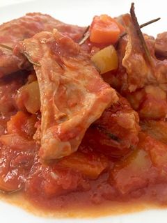 Una foto de Conejo con tomate y verduritas