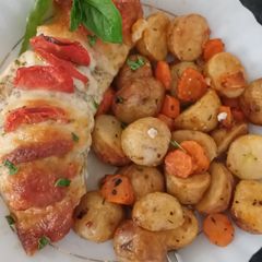 A picture of Hasselback chicken with pesto, mozzarella and tomatoes.
