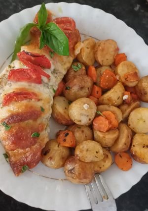 A picture of Hasselback chicken with pesto, mozzarella and tomatoes.