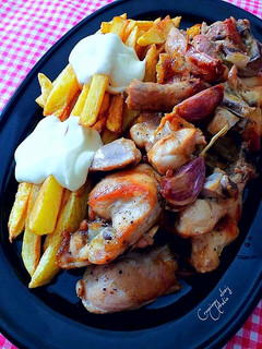 Una foto de Pollo confitado al ajillo con palos de patatas fritas y mayonesa