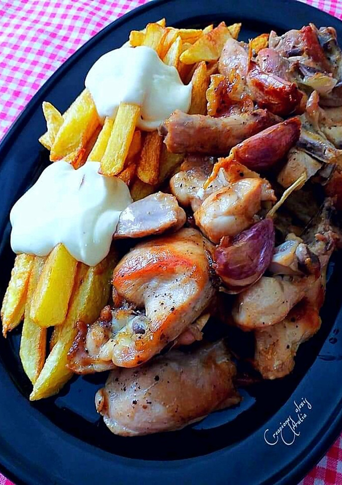 Una foto de Pollo confitado al ajillo con palos de patatas fritas y mayonesa
