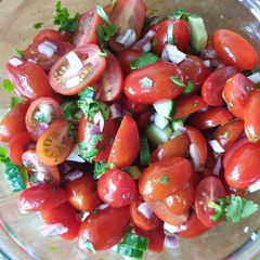 A picture of Baby plum tomato, cucumber, onion, chilli & coriander salad.
