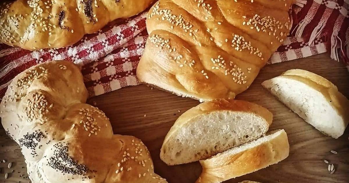 Donna affettare il pane con semi di sesamo sul tagliere sulla tavola di  legno da vicino