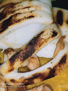 Una foto de Calamar a la plancha con langostinos al ajillo