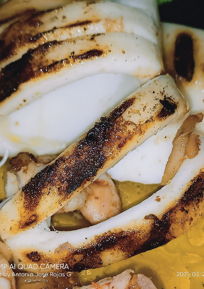 Una foto de Calamar a la plancha con langostinos al ajillo